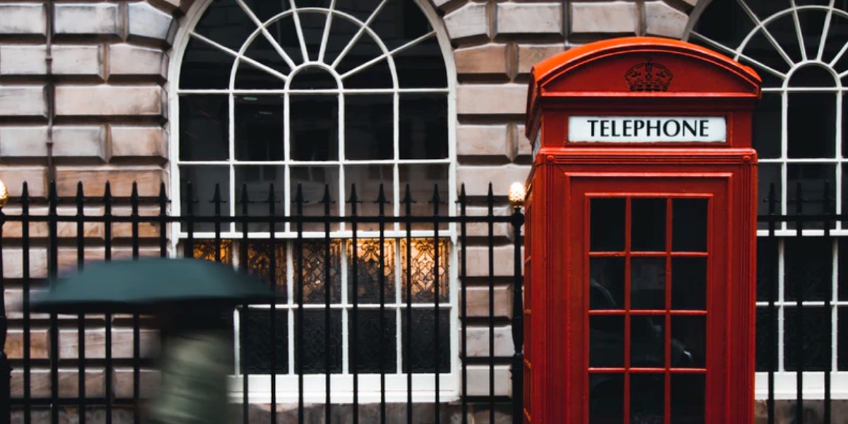a classic red telephone box in front of a typically London facade